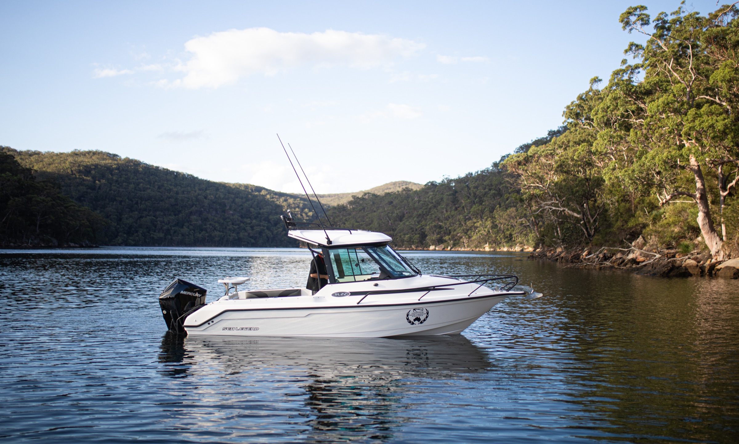 Boat moored on still water with rolling hills